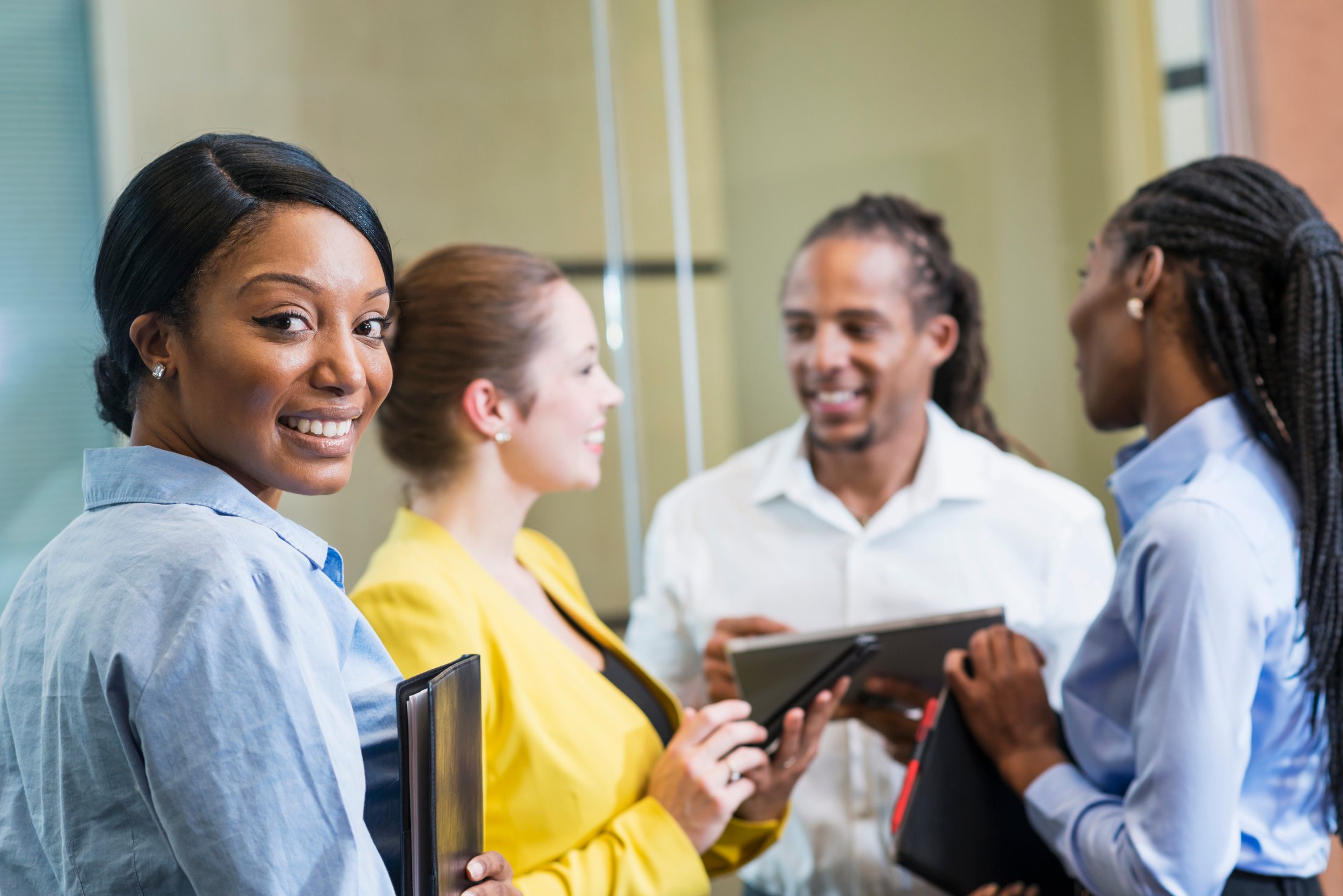 Black woman with group of business people smiling